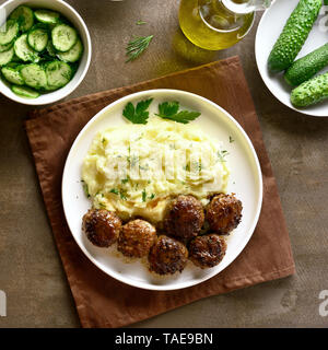 Hackfleisch Schnitzel mit Kartoffelbrei auf weißen Platte über braunen Hintergrund. Ansicht von oben, flach Stockfoto