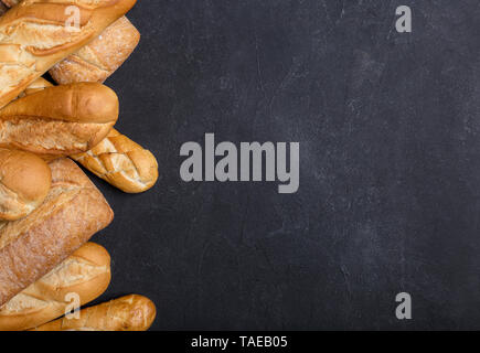 Verschiedene knuspriges Brot auf Schwarz. Rand links, Ansicht von oben mit Platz für Ihren Text. Konzept der Banner mit Brot Stockfoto