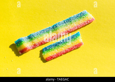 Farbige Marmelade in der Zucker auf dem gelben Hintergrund. Natürliche regenbogenfarbenen Marmelade Süßigkeit. Platz kopieren, leere Vorlage für Text Stockfoto