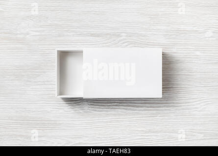 Leeres weißes Papier auf hellem Holz Tisch Hintergrund. Paket mockup. Branding mock up. Ansicht von oben. Flach. Stockfoto