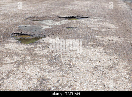 Großen Gruben mit Steinen auf der Asphaltstraße Stockfoto