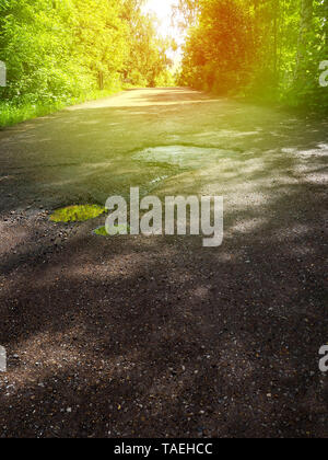 Große Gruben mit Steine auf dem Asphalt. Stockfoto