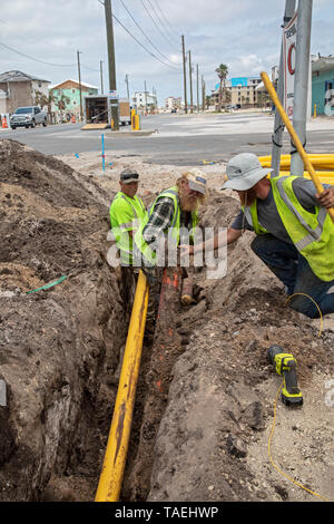 Mexiko Strand, Florida - Arbeiter ein Erdgas ersetzen Zeile sieben Monate nach der Stadt durch den Hurrikan Michael verwüstet wurde. Die orange beschädigt ist Stockfoto