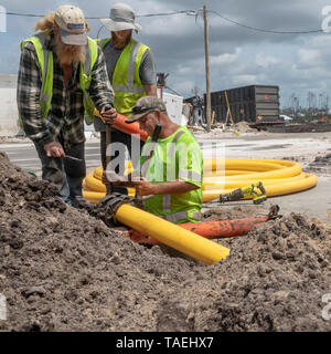 Mexiko Strand, Florida - Arbeiter ein Erdgas ersetzen Zeile sieben Monate nach der Stadt durch den Hurrikan Michael verwüstet wurde. Stockfoto