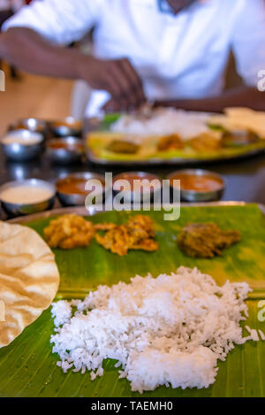 Vertikale Ansicht eines typischen vegetarisches Thali meal mit Händen in Indien gegessen wird. Stockfoto