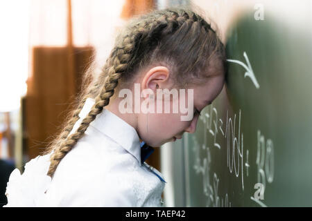 Ein Mädchen Schülerin ist müde neigt, mit Müdigkeit zu schlafen, den Kopf in die Schule. Stockfoto
