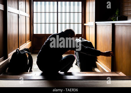 Traditionelle japanische machiya Haus oder Ryokan mit verschiebbaren Papier Tür Eingang und Licht mit Mann, der Architektur Stockfoto