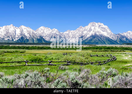 Ein Zaun mit der Grand Tetons im Hintergrund im Grand Teton National Park in der Nähe von Jackson Hole, Wyoming USA. Stockfoto