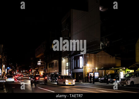 Kyoto, Japan - April 9, 2019: Straße in der Nähe von Maruyama Park Eingang in Gion Distrikt in der Nacht mit beleuchteten Gebäuden und Autos im Verkehr in dunklen blac Stockfoto