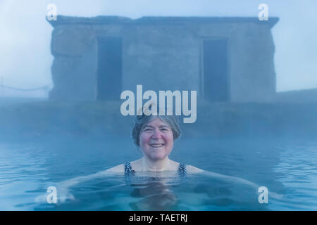 Karen Rentz Einweichen in die Geheime Lagune, eine natürliche heiße Quellen in Fludir, Island Stockfoto