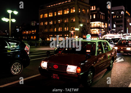 Kyoto, Japan - 9. April 2019: Street Bridge in der Nähe von Gion Distrikt in der Nacht mit beleuchteten Gebäuden und Autos Verkehr cab closeup im Verkehr in dunklen Bla Stockfoto