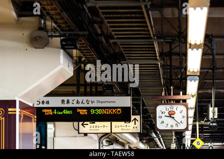 Tokio, Japan - April 4, 2019: Bahnhof Plattform lokale Linie nach Nikko Zeichen in Englischer Sprache und Architektur mit Uhr Stockfoto