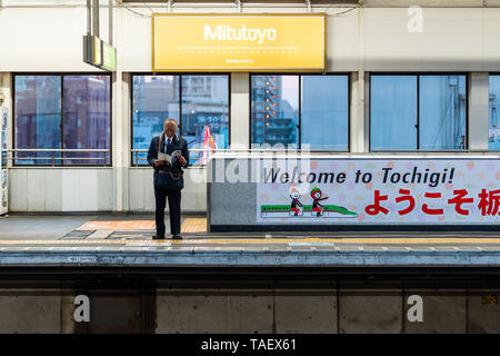 Tokio, Japan - April 5, 2019: Bahnhof Plattform mit Menschen für shinkansen am Abend wartet mit Willkommen Anmelden Englisch zu T Stockfoto