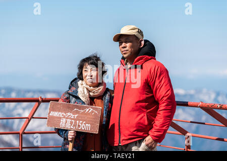 Takayama, Japan - April 8, 2019: Berg Schnee in Okuhida Dörfer Shinhotaka Seilbahn mit touristischen Paar posing Holding unterzeichnen Präfektur Gifu Park auf Stockfoto