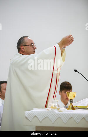 Zagreb, Kroatien - 11. Mai 2019: ein Priester holding Wafer über seinem Kopf auf dem Altar angehoben, während die erste heilige Kommunion, die Messe in der Kirche von St. Nikol Stockfoto