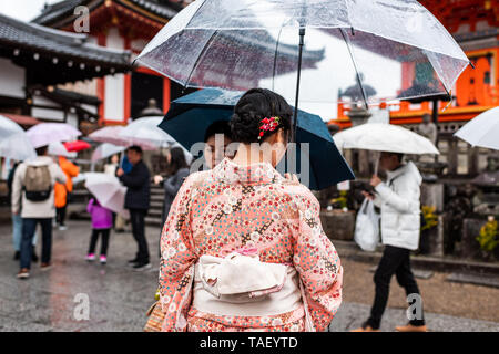 Kyoto, Japan - 9. April 2019: Viele Leute mit Kimono und Sonnenschirme während der regnerischen Tag im Tempel Kiyomizu-dera Stockfoto