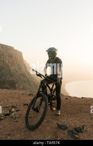 Spanien, Lanzarote, Mountainbiker auf einer Reise an der Küste bei Sonnenuntergang Stockfoto