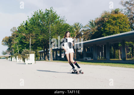 Spanien, junges Mädchen reiten Skateboard auf einer Straße Stockfoto