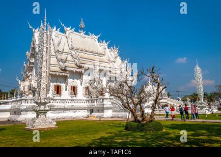 Chiang Rai, Thailand - Feb 2016: Touristen, die berühmten Chiang Rai weiße Tempel - Wat Rong Khun an einem sonnigen Tag. Stockfoto