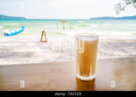 Frische organische Mango oder orange Schütteln im Thai Restaurant am Strand, in der Nähe von Meer in Insel Koh Phangan, Thailand. Close Up. Glas kalten Saft gegen Th Stockfoto