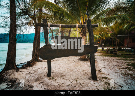 Holz- Schild am tropischen Strand. Ein Zeichen für den Namen des Hotels oder am Strand auf dem Hintergrund der wunderschönen Natur auf einer tropischen Insel. Stockfoto