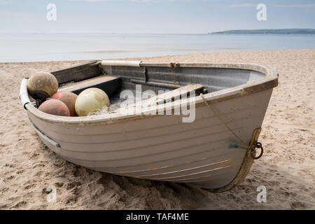 Altes Fischerboot am Strand in der Nähe von Bournemouth Branksome Chine mit dem Meer und Studland in der Ferne Stockfoto