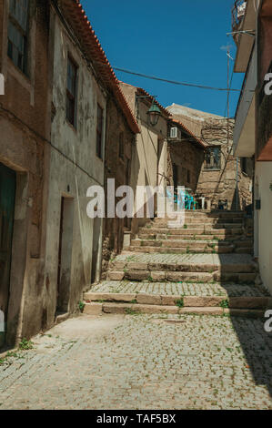 Alte Reihenhäuser mit verschlissenen Putz in einsame Gasse mit den Schritten am Hang in Belmonte. Geburtsort des Entdeckers Pedro CABRAL in Portugal. Stockfoto