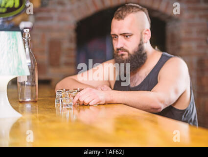 Alkohol Konzept süchtig. Hipster brutalen Mann, Alkohol zu trinken bestellen mehr Getränke an der Theke. Alkoholismus und Depression. Kerl verbringen Freizeit in bar mit Alkohol. Mann betrunken sitzen alleine in eine Kneipe. Stockfoto