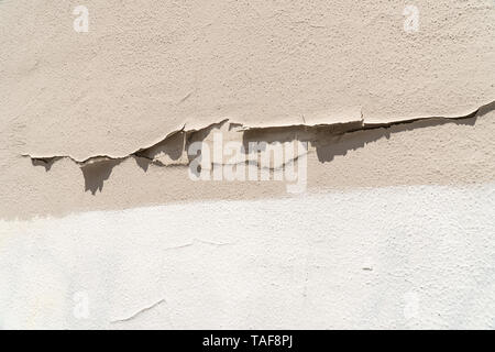 Weiß und Beige gestrichene Wand mit abblätternder Farbe. Zusammenfassung Hintergrund Stockfoto