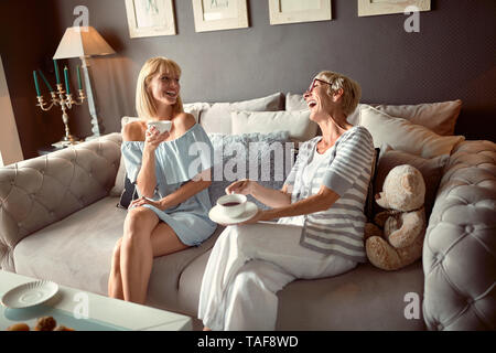 Freundliche ältere Frau mit Tochter Kaffee trinken und plaudern Stockfoto