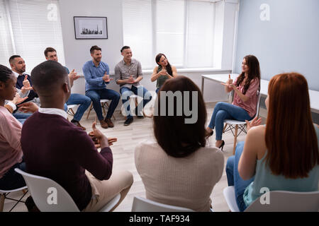 Gruppe von Jugendlichen lernen Gehörlose Geste Zeichen von Frau sitzt auf Stuhl Stockfoto