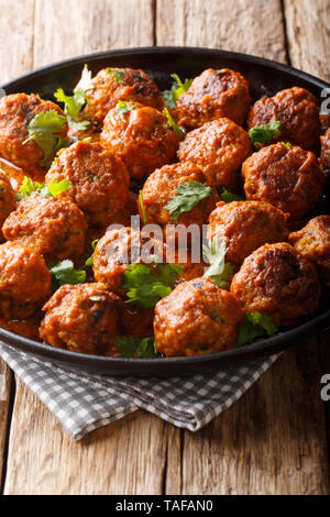 Chicken Fleischbällchen in einer cremigen coconut Sauce mit Curry closeup auf einem Teller auf den Tisch. Vertikale Stockfoto