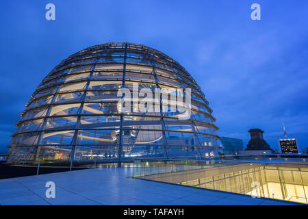 Beleuchtete Glaskuppel auf dem Reichstag (Deutscher Bundestag) Gebäude in Berlin in der Dämmerung. Fernsehturm Fernsehturm im Hintergrund. Stockfoto