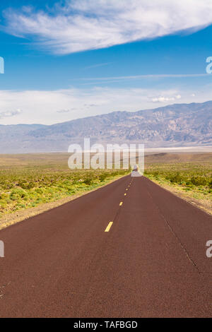 Trona Wildrose Straße, die zum Death Valley in Kalifornien an einem schönen sonnigen Tag mit blauem Himmel und die Berge als Hintergrund führt. Stockfoto