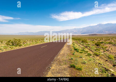 Trona Wildrose Straße, die zum Death Valley in Kalifornien an einem schönen sonnigen Tag mit blauem Himmel und die Berge als Hintergrund führt. Stockfoto