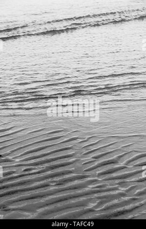 3monochromatischen Bilder von ebbing Tide - gewinkelt Klein wavelets - und Wasser plätscherte Sand markiert. Metapher "Tide und Zeit', klicken Sie mit der Strömung. Stockfoto