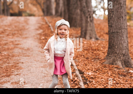 Lachendes Baby Mädchen mit trendiger Winterkleidung im Freien. Mit Blick auf die Kamera. Herbst Saison. Stockfoto