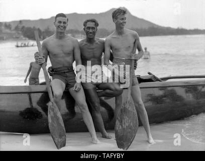 Hawaiian Surf Legende, Duke Kahanamoku, mit FDR Söhne Franklin D. Roosevelt, Jr. und John Roosevelt am Strand von Waikiki in Honolulu, Hawaii. Präsident Roosevelt, zusammen mit seinen Söhnen, reiste an Bord der USS Houston nach Hawaii im Jahr 1934, der der erste Besuch war eines sitzenden US-Präsident für das Gebiet. Duke Kahanamoku gab private Surfen Lektionen an die Roosevelt Söhne und ihre Partei während Ihrem Aufenthalt in Waikiki. Stockfoto