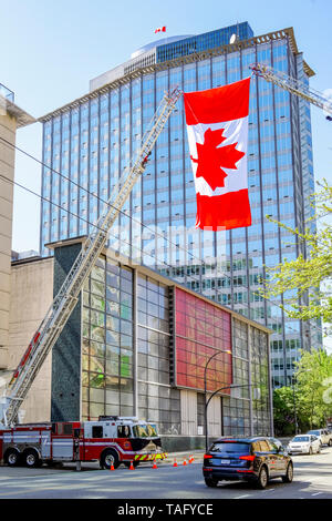 Kanadische Flagge helsd aloft durch 2 Fire Truck Leitern in Gruß zu Feuerwehrmann, die auf Aufgabe gestorben, Vancouver, British Columbia, Kanada Stockfoto