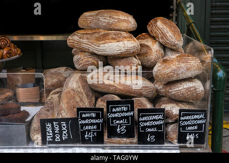 Spezialität Brot Borough Market Bäckerei "Brot" mit einer Vielzahl an attraktiven hand Stall gemacht Artisan Brot auf Anzeige zum Verkauf mit weißen Sauerteigbrot im Vordergrund angezeigt. Artisan Spezialität Bäckerei am Borough Market Southwark London UK Abschaltdruck Stockfoto