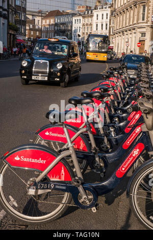 London TFL Santander geförderte Linie der roten Fahrradverleih Fahrräder in Southwark Street mit London Black Cab hinter sich. Fahrrad terminal Docking Station. Transport for London Southwark London UK Stockfoto