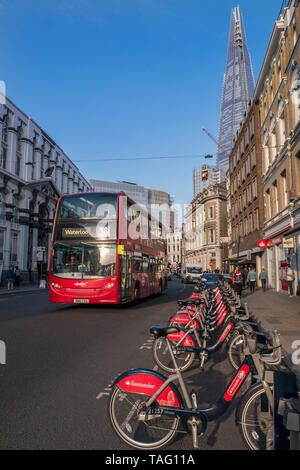 Fahrräder London TFL Santander gesponserte Linie von roten Leih-Fahrräder Fahrräder Fahrräder in Southwark Street mit roten Londoner Bus und das Shard Gebäude dahinter. Fahrradterminal Dockingstation. Transport nach London Southwark London UK Stockfoto