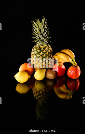 Frische Früchte tragen auf schwarzem Hintergrund. Isolierte Früchte Stockfoto