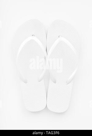 Die leeren, weißen Flip Flops auf einem weißen Hintergrund. In der Nähe von farbloses Bild. Helle, high key Exposition. Stockfoto