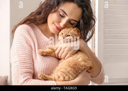 Junge Frau mit niedlichen lustige Katze zu Hause Stockfoto