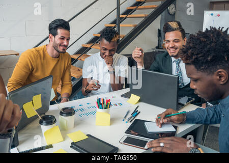 Die internationale Kommunikation. Junge Menschen verschiedener Nationalitäten kommunizieren und Lachen im Büro. Stockfoto