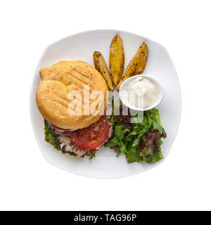 Hamburger mit Sauce und Kartoffeln auf einer Platte auf einem weißen Hintergrund, Ansicht von oben Stockfoto