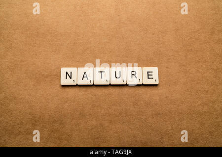 LONDON, UK, 24. Mai 2019: Das Wort Natur Dinkel mit hölzernen Buchstabensteine über eine braune strukturierten Hintergrund Stockfoto