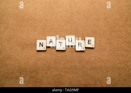 LONDON, UK, 24. Mai 2019: Das Wort Natur Dinkel mit hölzernen Buchstabensteine über eine braune strukturierten Hintergrund Stockfoto