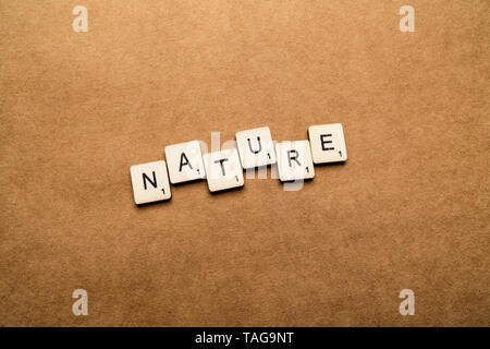 LONDON, UK, 24. Mai 2019: Das Wort Natur Dinkel mit hölzernen Buchstabensteine über eine braune strukturierten Hintergrund Stockfoto